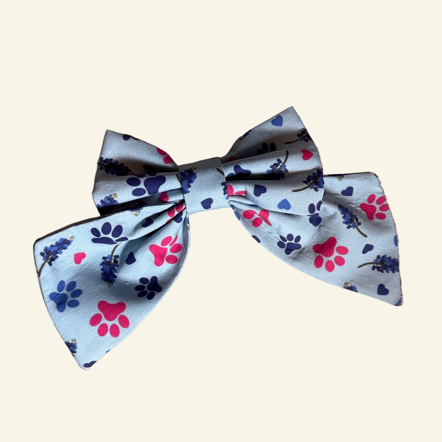 Fabric bow with paw print pattern on a beige carpet
