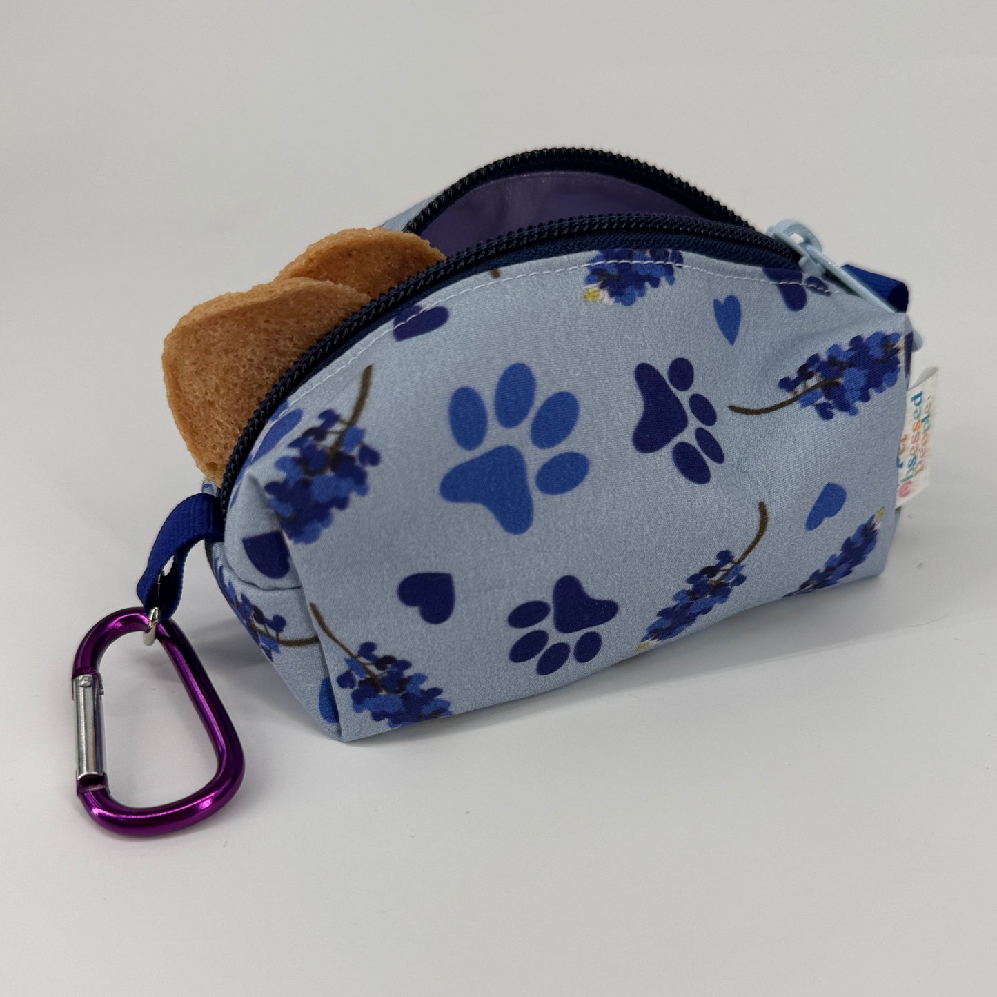 Pet treat pouch with blue paw print pattern on a white background